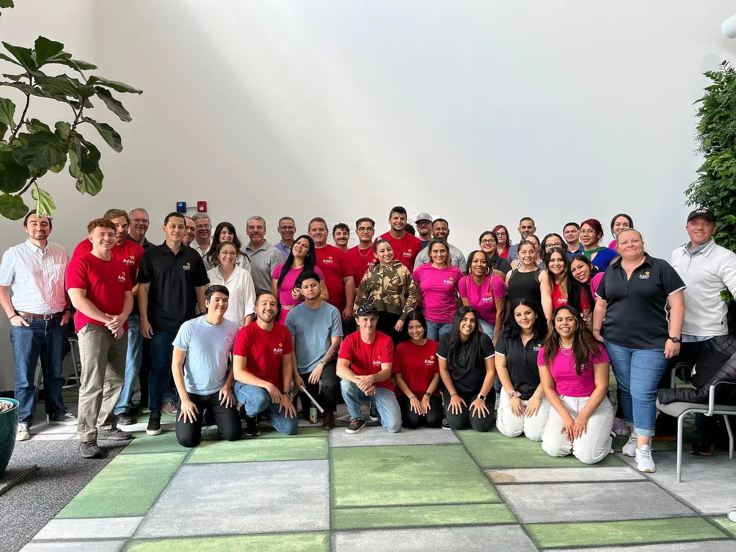 The Aden Logistics team posing for a picture in front of a white wall.